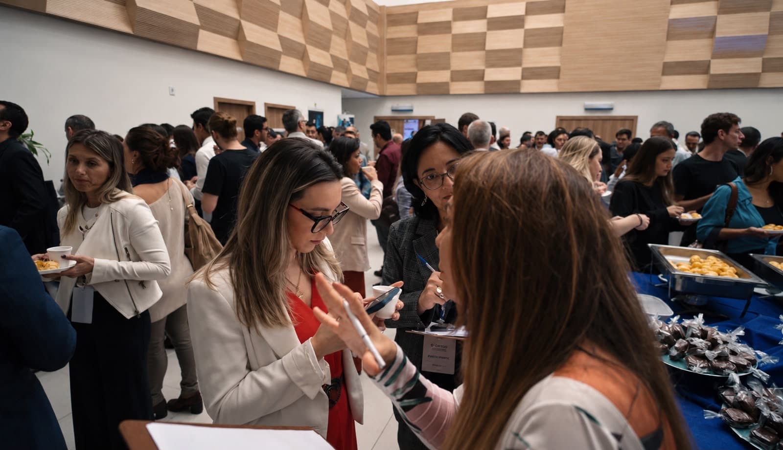Participantes conversando com café na mão durante o intervalo
