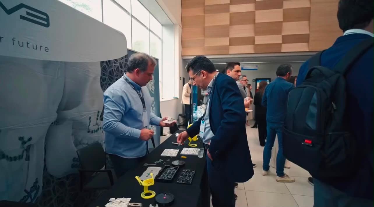 Participantes examinando produtos no estande de um parceiro, durante o intervalo